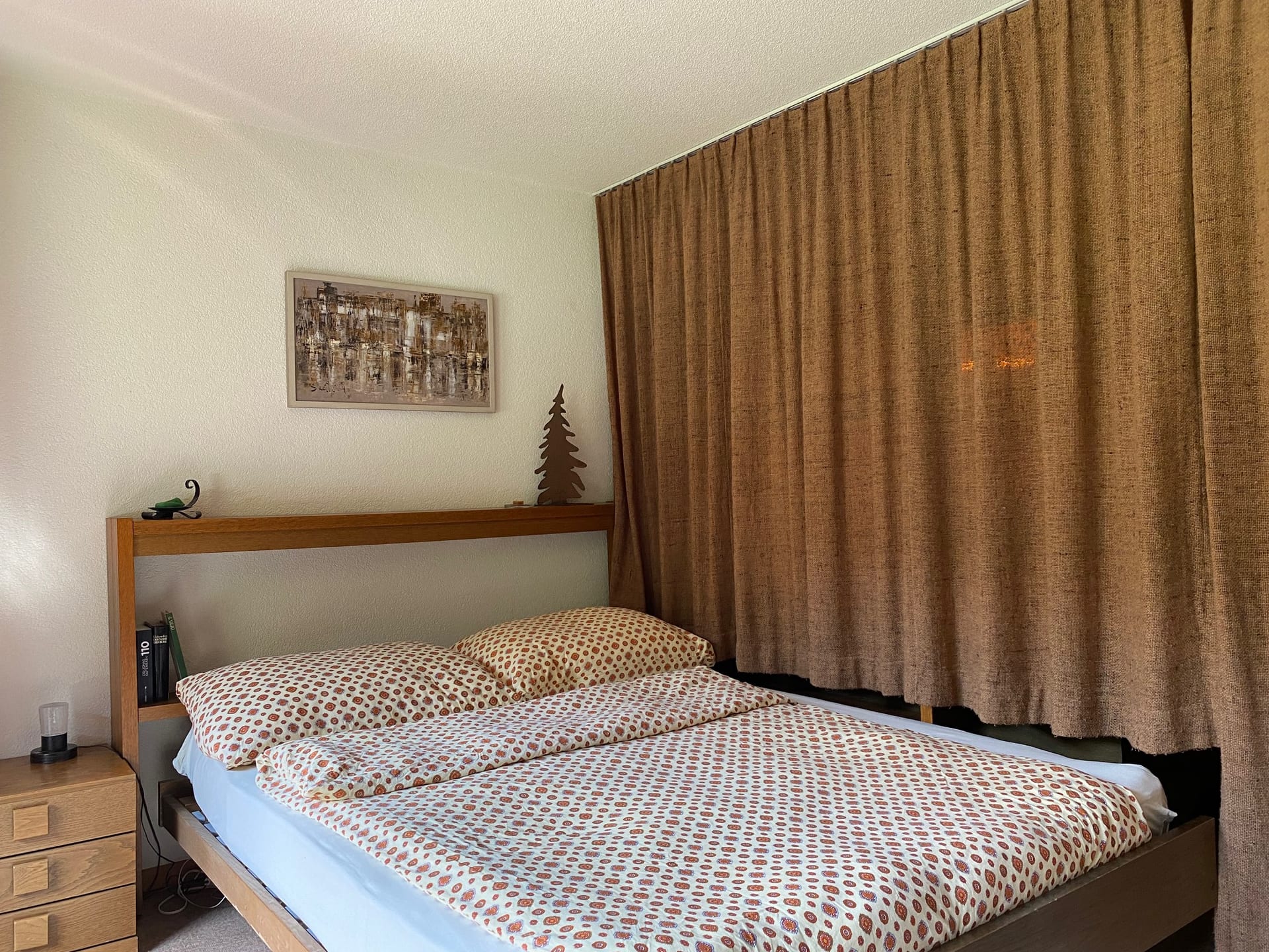 Doppelbett hinter dem Raumteiler mit zugezogenem Vorhang